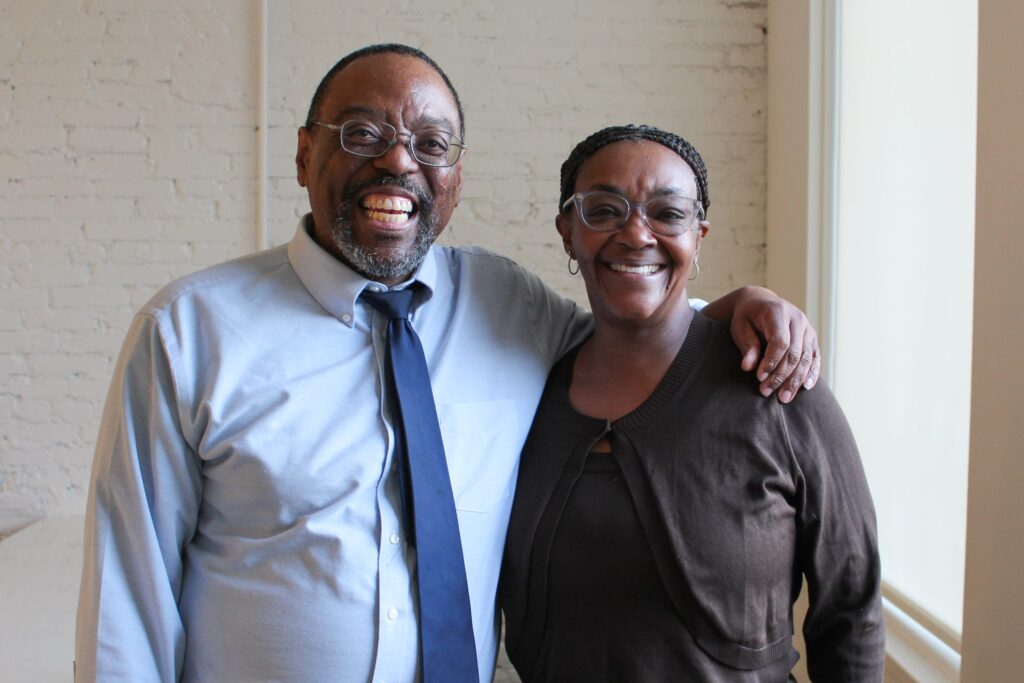 Professors George and Joy Comer smile arm in arm.